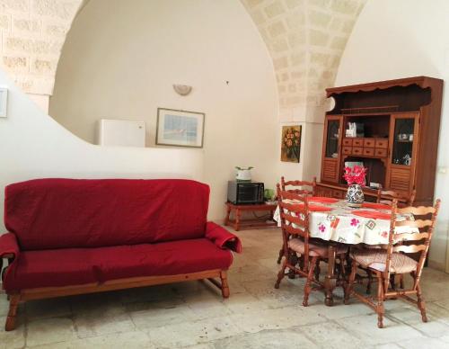 comedor con sofá rojo y mesa en Ostuni Centro en Ostuni