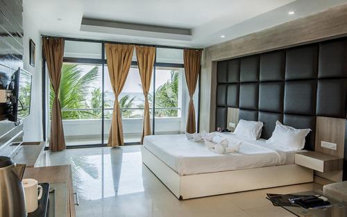 a bedroom with a large bed and a large window at Hotel Sonar Bangla Mandarmoni in Mandarmoni