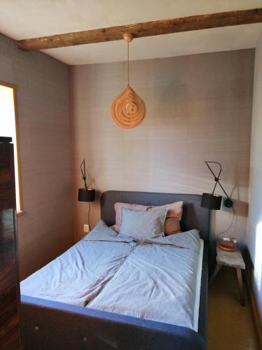 a bedroom with a bed with a blue headboard at Dobry Dom in Sejny