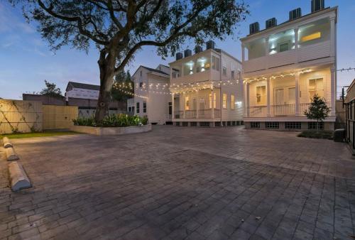 a large white building with a tree in front of it at Fabulous Cottages with City Views in New Orleans