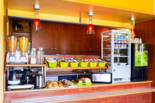 a kitchen with a counter with food and a refrigerator at ibis budget Chartres in Chartres