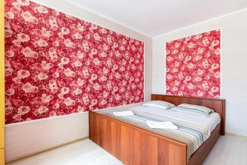 a bedroom with a bed and a red floral wall at RentWill CROCUS 246 in Krasnogorsk