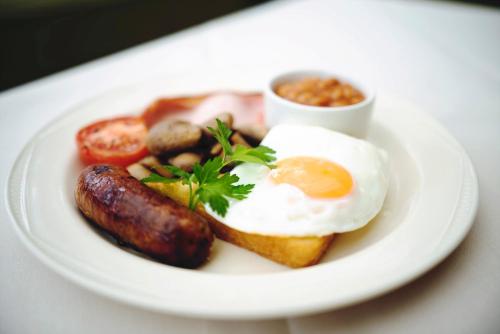 een bord ontbijtproducten met eieren, worst en toast bij Gardenia Boutique Hotel in Johannesburg