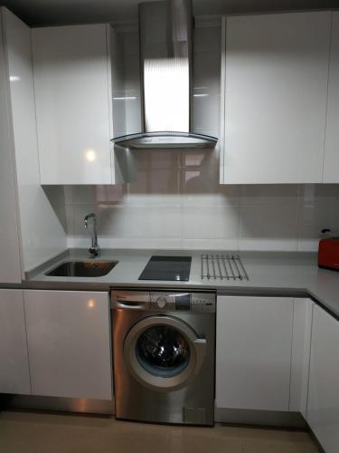 a kitchen with a washing machine and a sink at Apartamento Edificio Plaza Gran Vía in Salamanca