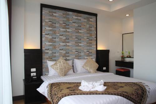 1 dormitorio con 1 cama grande y toallas. en Serene Residence, en Kanchanaburi