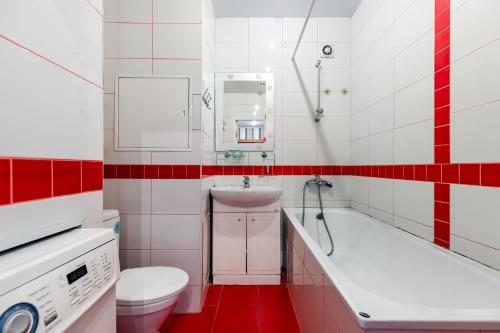 a red and white bathroom with a toilet and a sink at RentWill CROCUS 246 in Krasnogorsk