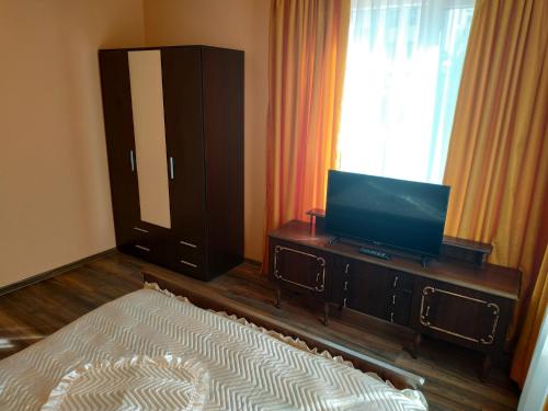 a bedroom with a tv on a dresser with a bed at ВИЙГ in Sapareva Banya