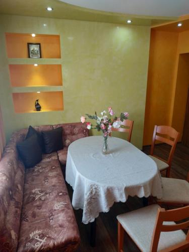 a couch and a table with a vase of flowers on it at ВИЙГ in Sapareva Banya