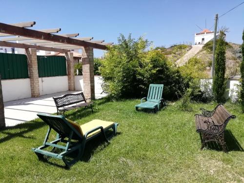 a group of chairs sitting in the grass at Casa Luminosa in Carrapateira