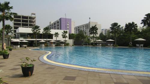 a large swimming pool in the middle of a city at Swift Inn Aeropolis Airport in Tangerang