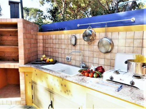 una cocina con fregadero y fruta en la barra en Casa Mutreku one minute from the beach in Sos Alinos, en Cala Liberotto