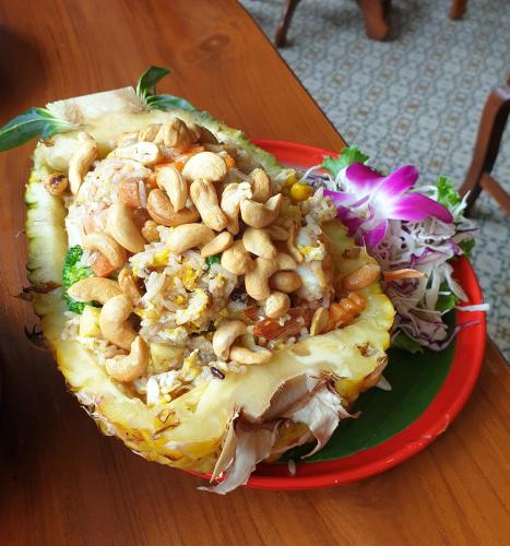 a plate of food with pasta and nuts on a table at Vieng Mantra Hotel in Chiang Mai