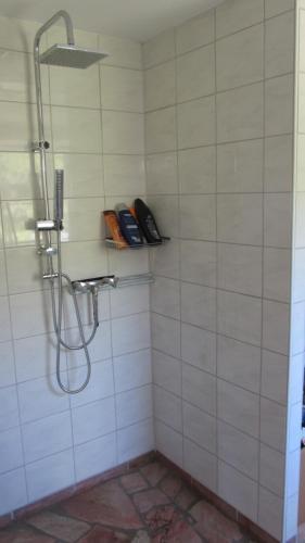 a shower in a white tiled bathroom at Idylle in ländlicher Umgebung in Weitenhagen