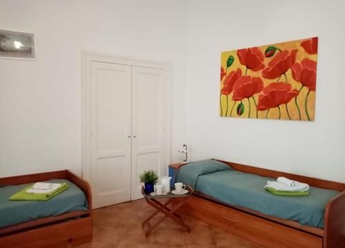 um quarto com duas camas e um quadro na parede em Da Rossana em Procida