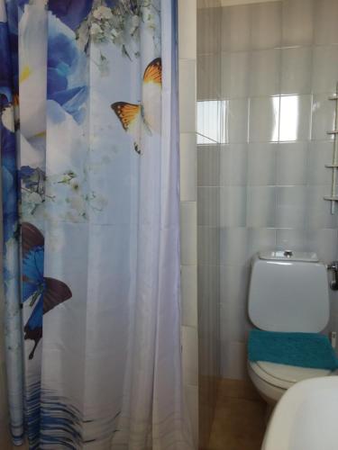 a bathroom with a shower curtain with butterflies on it at Chambre d hôtes chez raymonde et sandrine in Luri