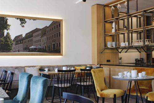 un restaurant avec des tables et des chaises et une photo sur le mur dans l'établissement Hotel Ross, à Meissen