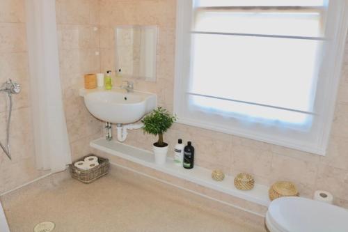 ein Bad mit einem Waschbecken, einem WC und einem Fenster in der Unterkunft The Ness in Whitstable