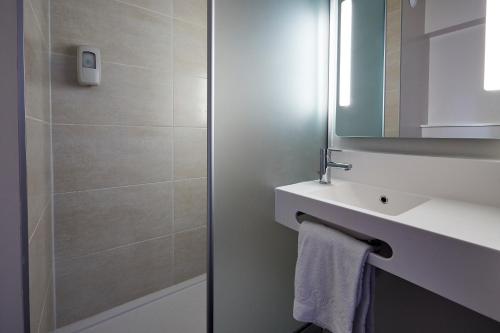 uma casa de banho com um lavatório e um espelho em B&B HOTEL Montpellier Vendargues em Saint-Aunès