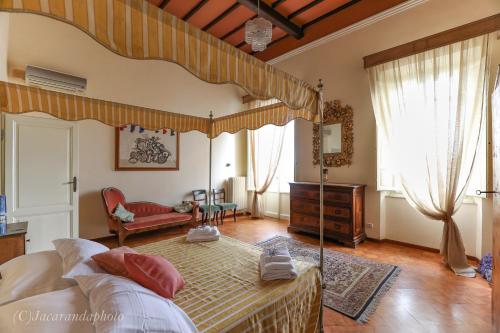 Un dormitorio con cama con dosel y una sala de estar. en Domus Lilia, en Viareggio