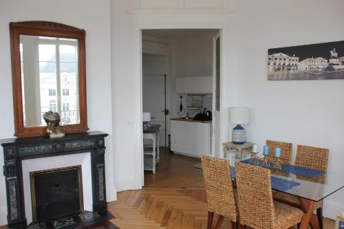 - un salon avec une cheminée, une table et des chaises dans l'établissement Appartement F3 au balcon de la Place du Martroi, à Orléans