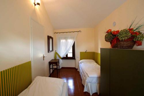 Habitación pequeña con 2 camas y ventana en Il Giardino Segreto en Luino
