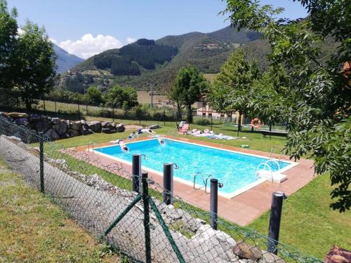 a swimming pool with people in a resort at Chalet turístico La Jenduda in Ojedo