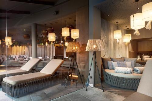 a living room with a couch and chairs and lights at Krumers Alpin – Your Mountain Oasis in Seefeld in Tirol