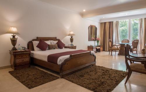 a bedroom with a bed and a table and chairs at Diplomat, Chanakyapuri New Delhi- A Boutique Hotel in New Delhi