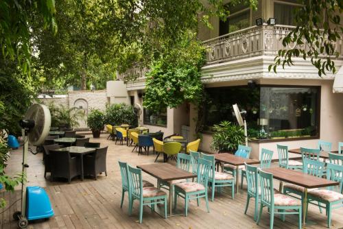 a patio with tables and chairs in front of a building at Diplomat, Chanakyapuri New Delhi- A Boutique Hotel in New Delhi
