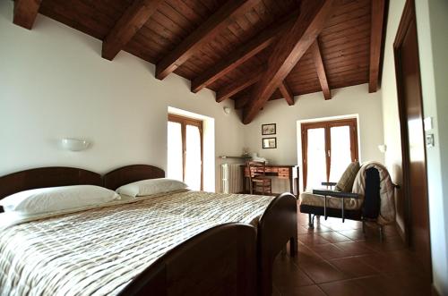 una camera con un grande letto in una stanza con soffitti in legno di Agriturismo Ca' del Sartu a Bobbio