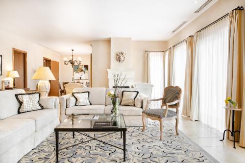 a living room with a couch and a table at Terre Blanche Hotel Spa Golf Resort in Tourrettes