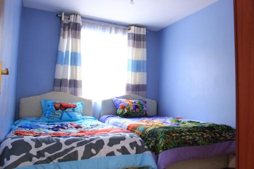 En eller flere senger på et rom på Essy's Apartments Nakuru with pool & GYM