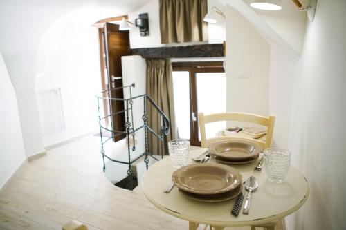 einem Esstisch mit Tellern und Besteck in der Unterkunft HOME 5 - Giù in Dimora in Putignano