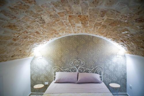 Schlafzimmer mit einem Bett mit Steindecke in der Unterkunft HOME 5 - Giù in Dimora in Putignano
