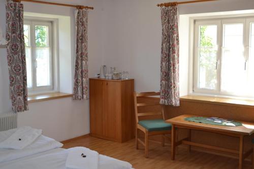 Zimmer mit einem Bett, einem Schreibtisch und Fenstern in der Unterkunft Gingin- rooms in Hallstatt