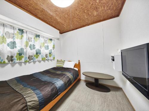 a bedroom with a bed and a flat screen tv at Hotel Hamby Resort in Chatan