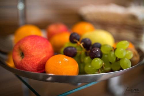 a metal bowl of fruit on a table at Hotel Garni Sonnenklahr in Göhren
