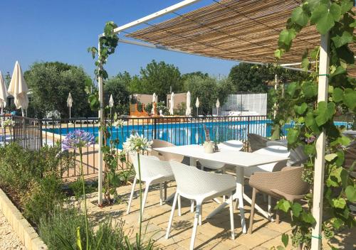 a patio with a table and chairs and a pool at Vacanze Glamping Boutique in San Felice del Benaco