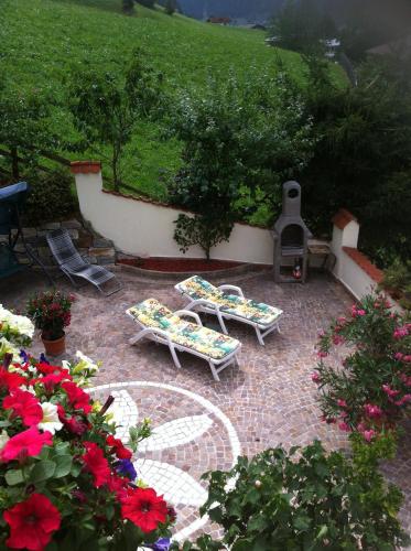 a patio with two lounge chairs and a fireplace at Appartementhaus Olympia Schlössl in Neustift im Stubaital