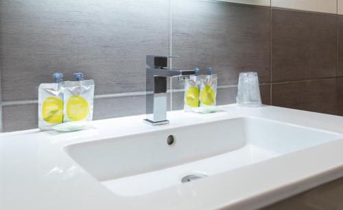 a bathroom sink with a faucet and a mirror at Hôtel de l'Europe Grenoble hyper-centre in Grenoble