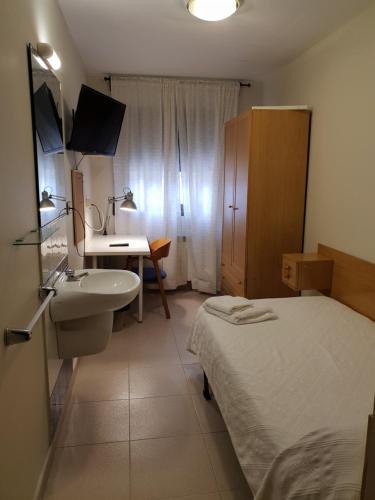 ein kleines Bad mit einem Bett, einem Waschbecken und einem Waschbecken in der Unterkunft Residencial Oscense in Huesca