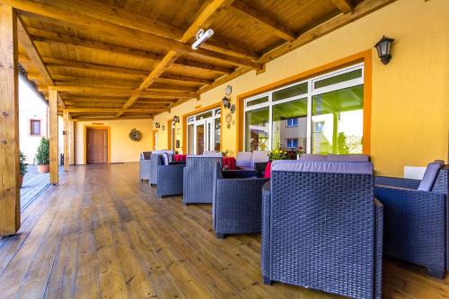 a dining room with blue chairs and windows at Hotel & Motorest V Údolí Zlatého potoka in Blšany