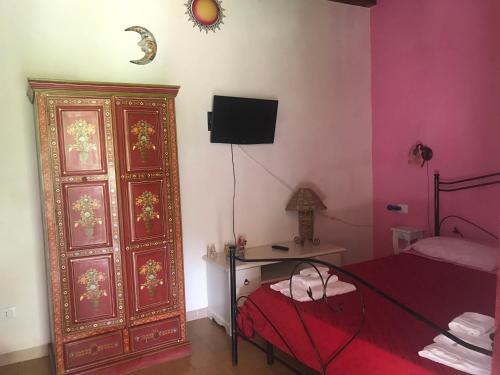 ファヴィニャーナにあるAppartamenti Calarossa O' Cafe'のベッドルーム1室(ベッド1台付)、大きな木製キャビネットが備わります。