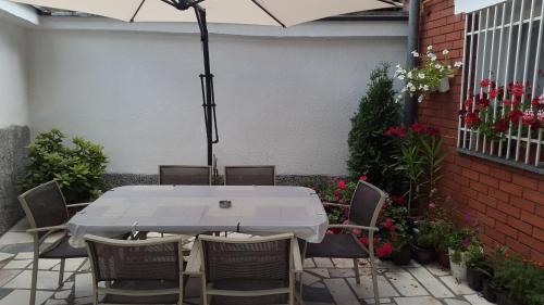 a white table and chairs with an umbrella on a patio at Little Paradise in Sarajevo