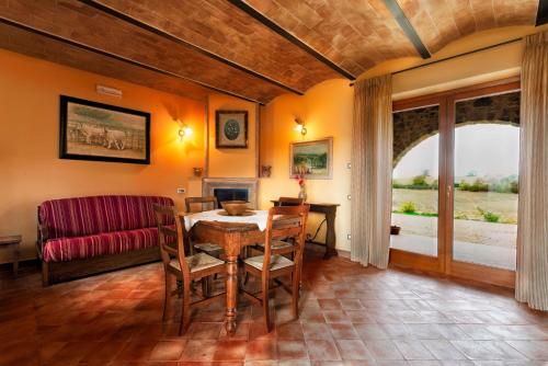 uma sala de jantar com uma mesa e cadeiras e um sofá em Il Grottino di Saturnia em Saturnia