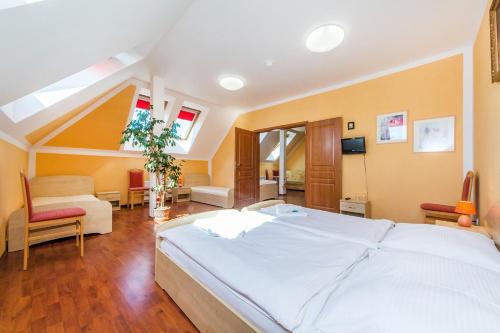 a bedroom with a large white bed in a room at Hotel & Motorest V Údolí Zlatého potoka in Blšany