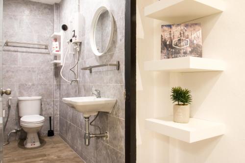 a bathroom with a sink and a toilet at Neveu Premier Residence : Ratchada in Bangkok