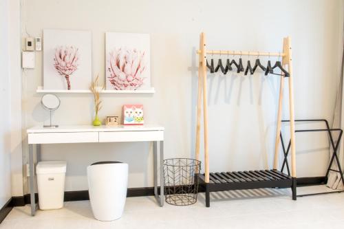 a dressing room with a white table and a shelf at Neveu Premier Residence : Ratchada in Bangkok