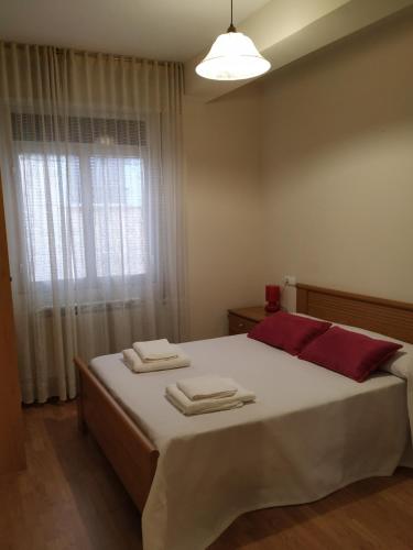 a bedroom with a large bed with towels on it at Camino Real in Molinaseca