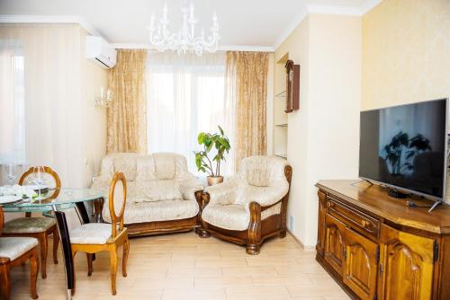 a living room with a tv and a table and chairs at Apart Reserve Sloboda Suite in Ivano-Frankivsʼk